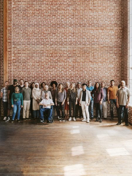 Group of diverse people standing in front of a brick wall
